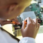 faceless professional repairer fixing video card in service center